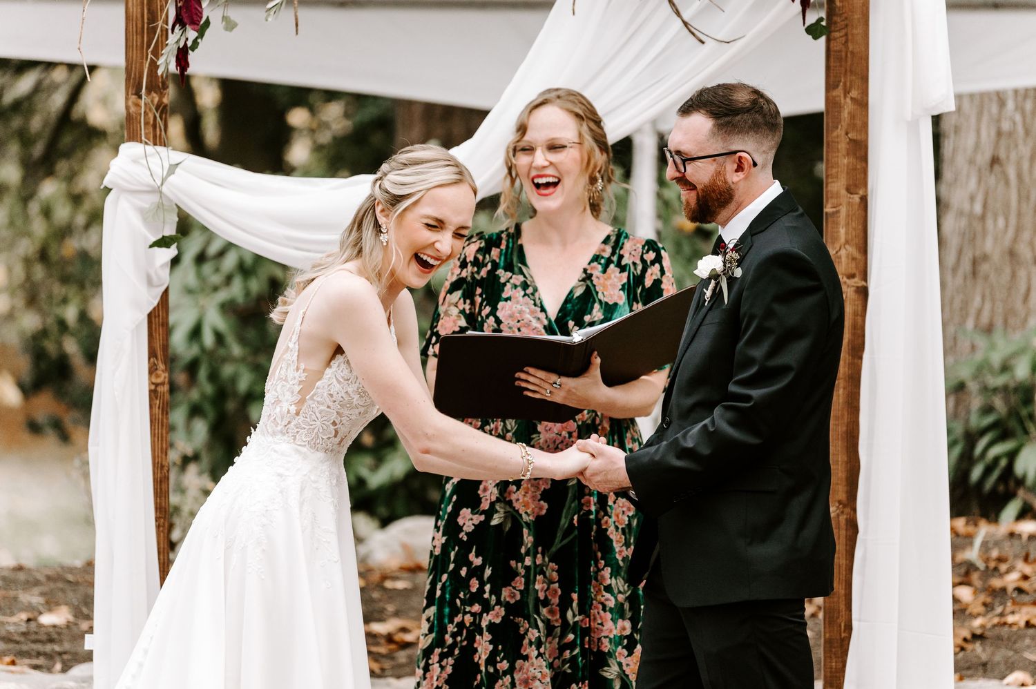 Wedding party laughing and celebrating during outdoor ceremony.
