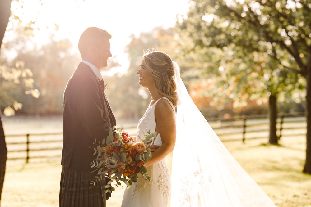 Bride and groom looking lovingly at each other with golden sunlight