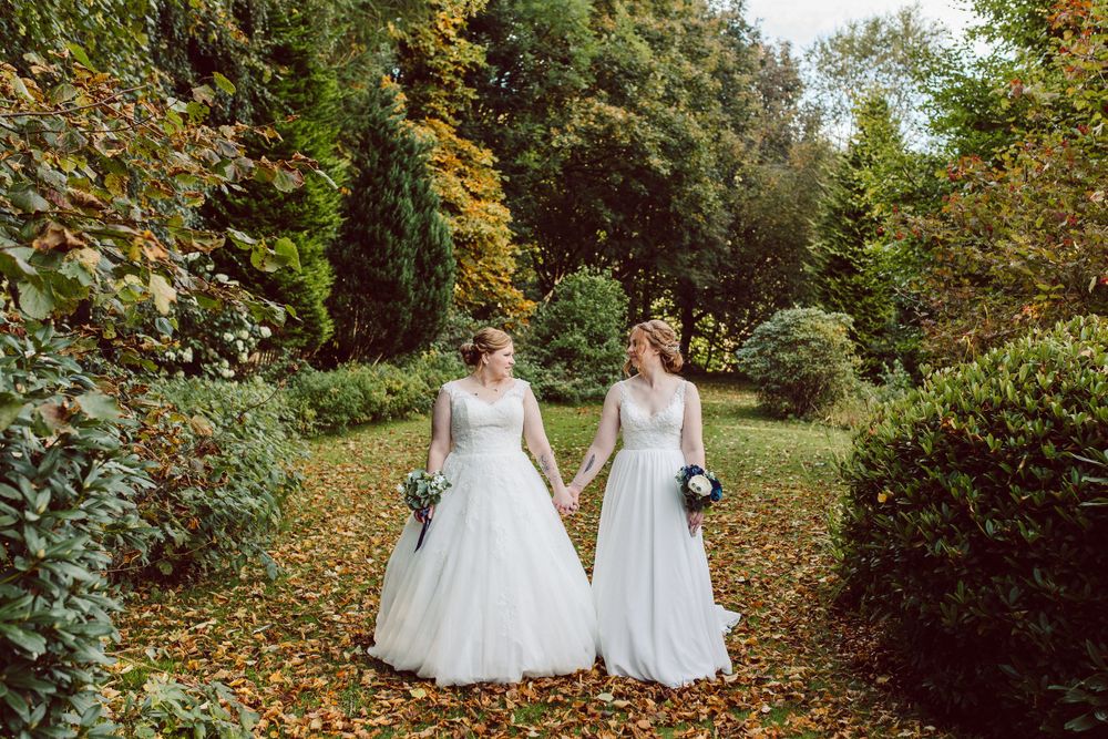 two brides looking at each other whilst surrounded by tress in autumn, Scotland