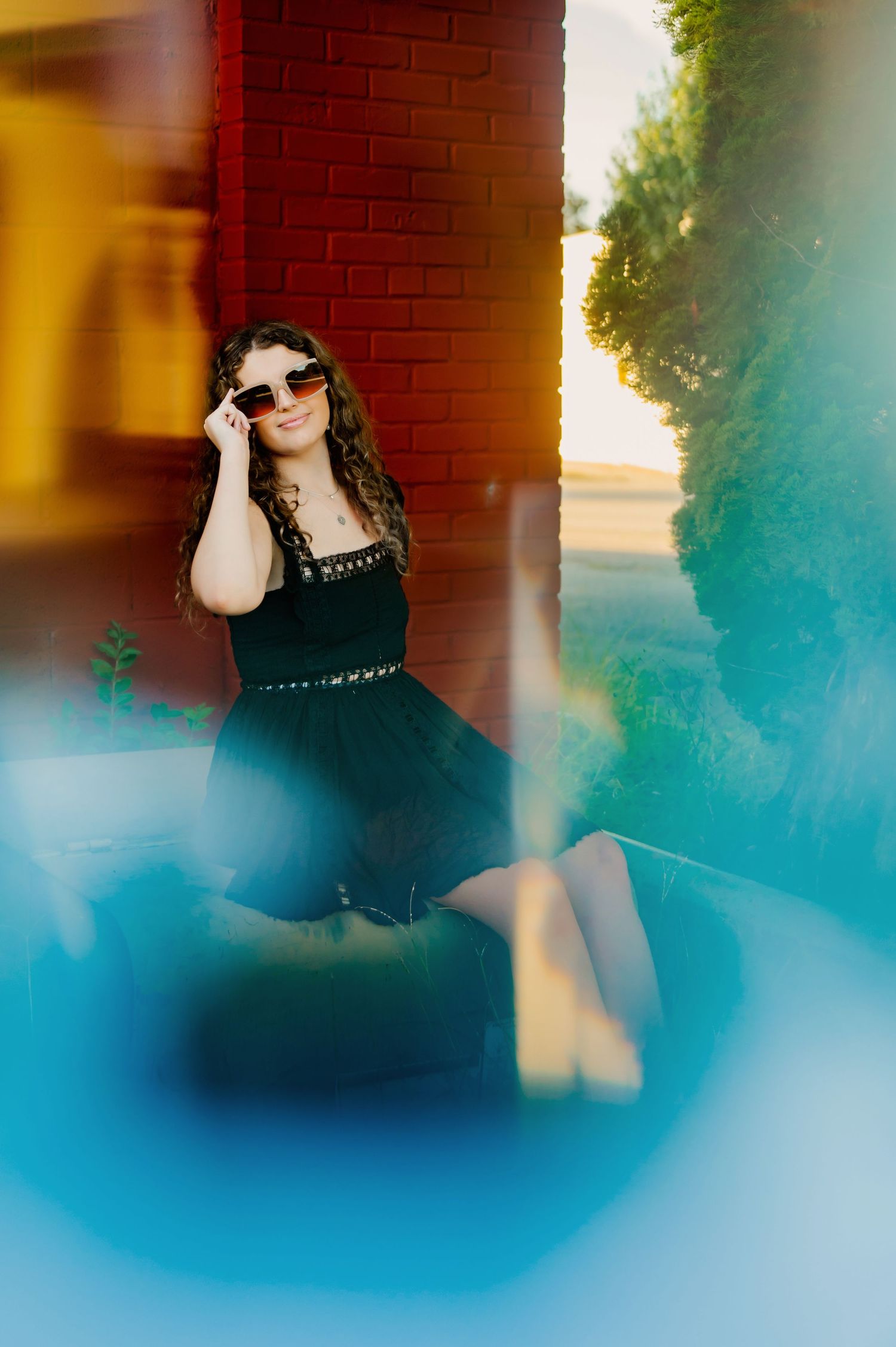 An artistic fashion photo with color effects featuring a black dress against a vibrant background.