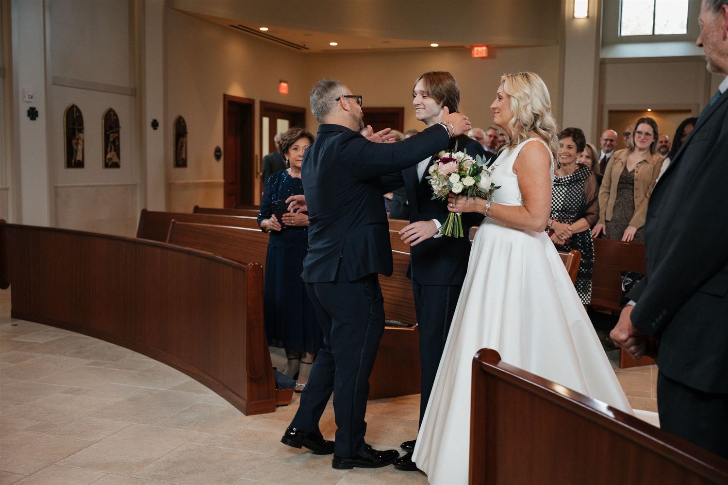 Joyful moment during wedding ceremony with bride in white ball gown.