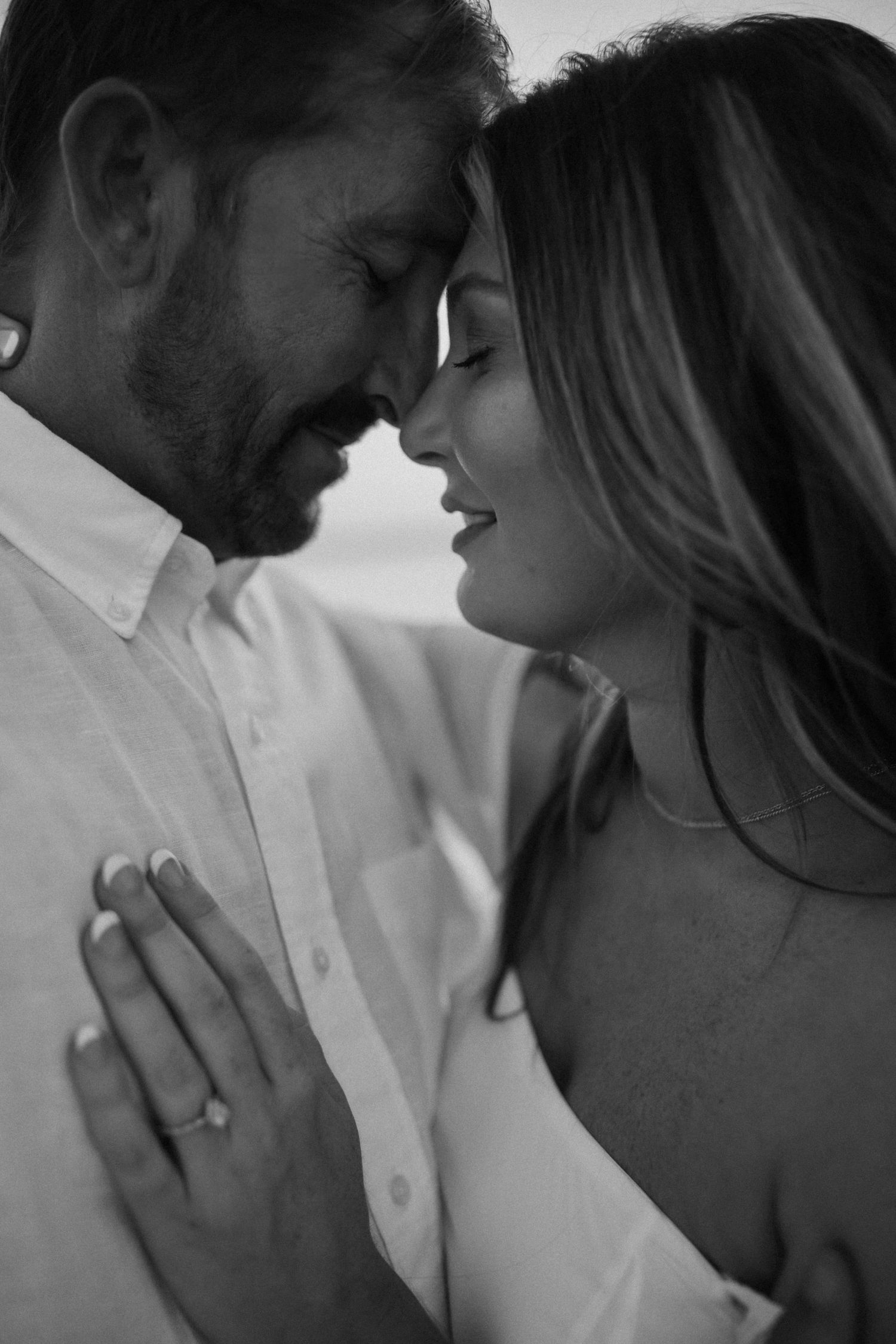Intimate black and white portrait of couple sharing tender moment.