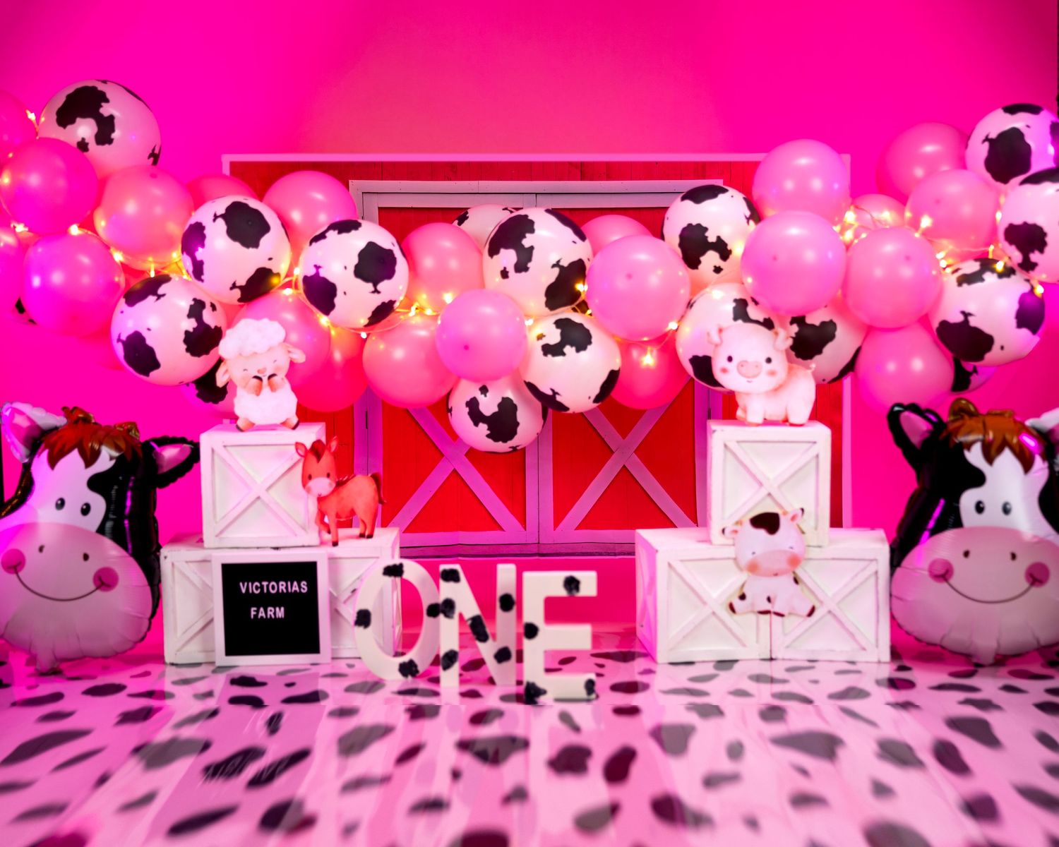 Pink Minnie Mouse themed party setup with polka dot balloons and white decorative boxes.