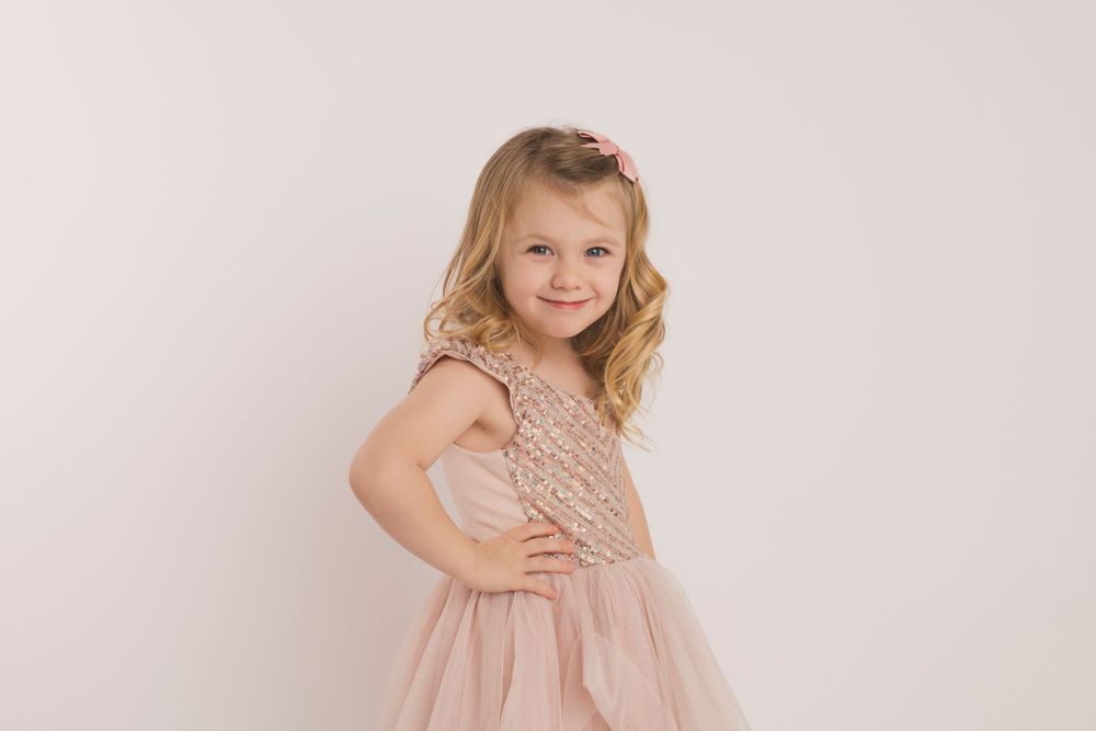 Portrait in pink dress against neutral background.