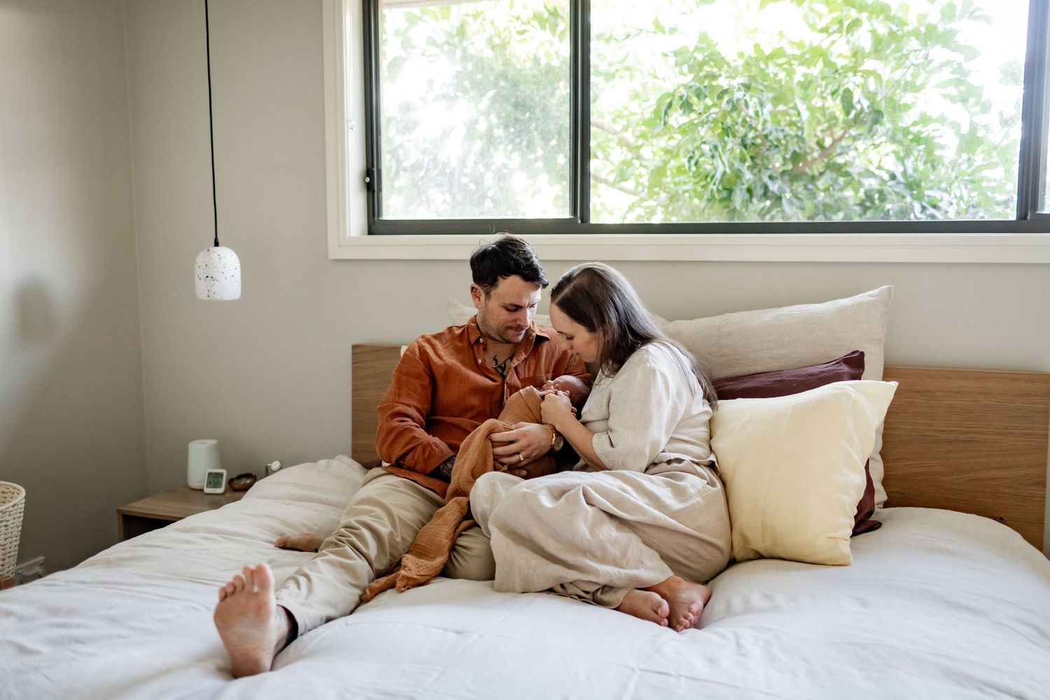 Cozy lifestyle portrait of couple relaxing together on white bed.