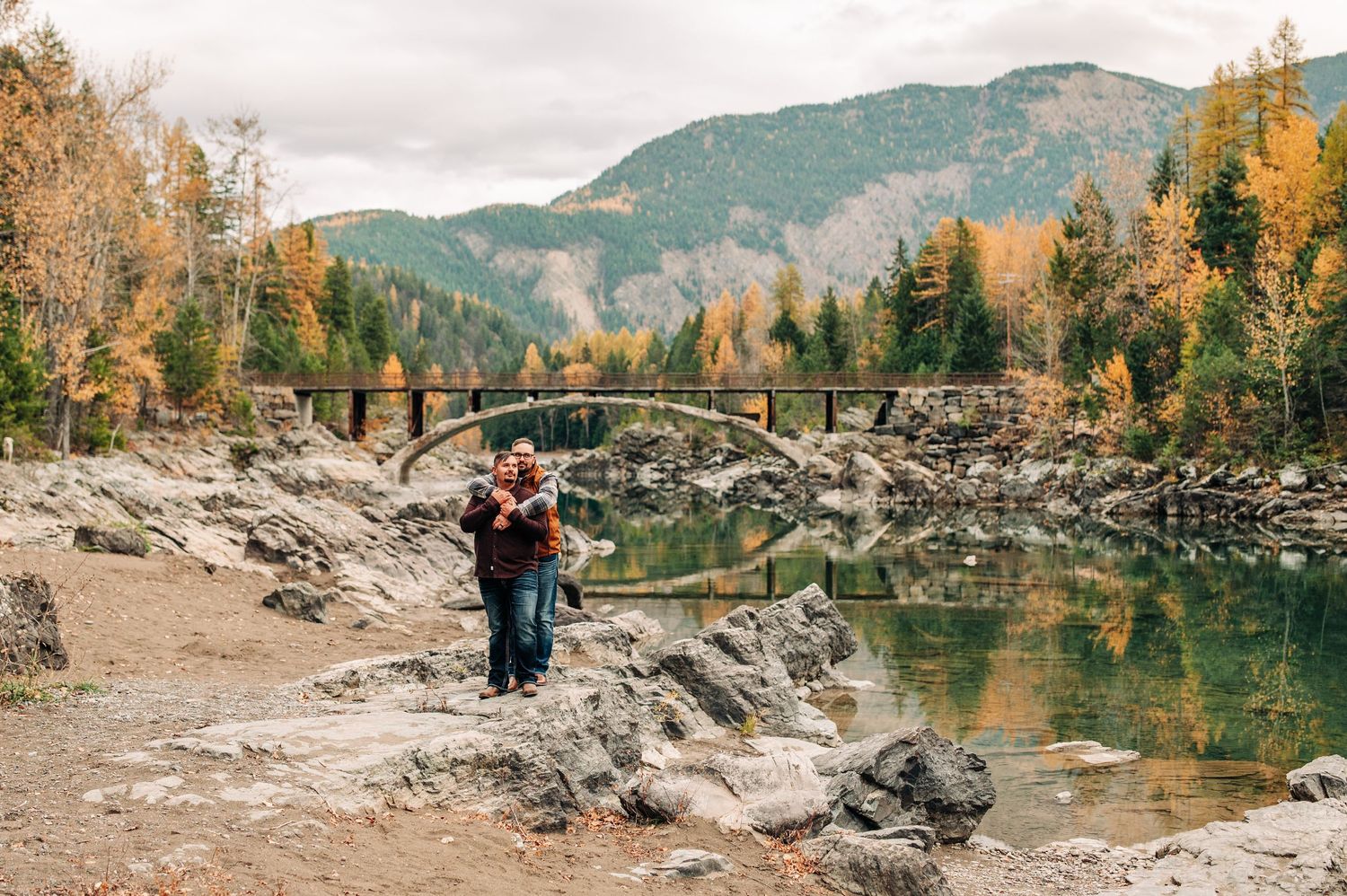 couple standing together along the river at Belton bridge in west glacier