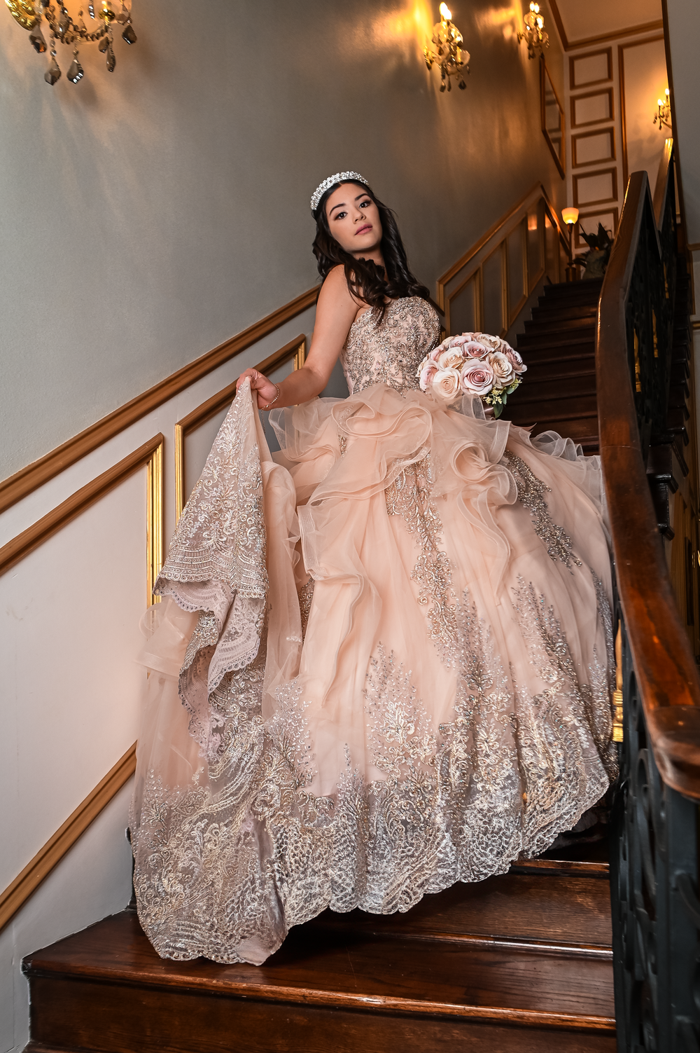 Stunning blush ballgown with lace detailing photographed on vintage wooden staircase.