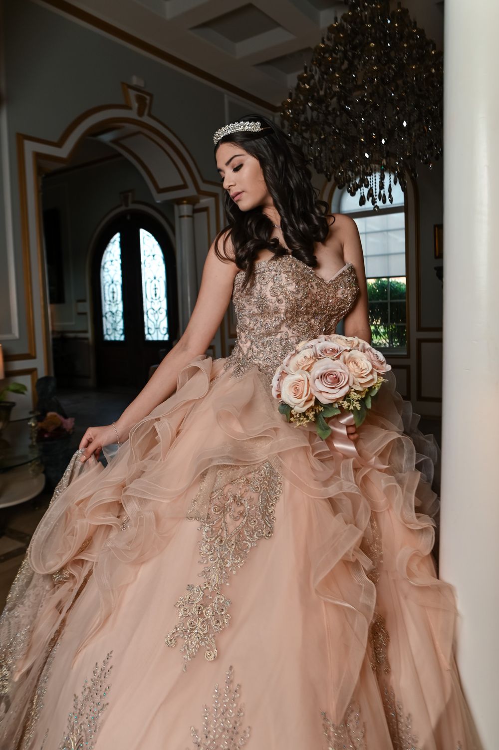 Detailed view of peach-colored ballgown with intricate beadwork and flowing ruffled skirt.