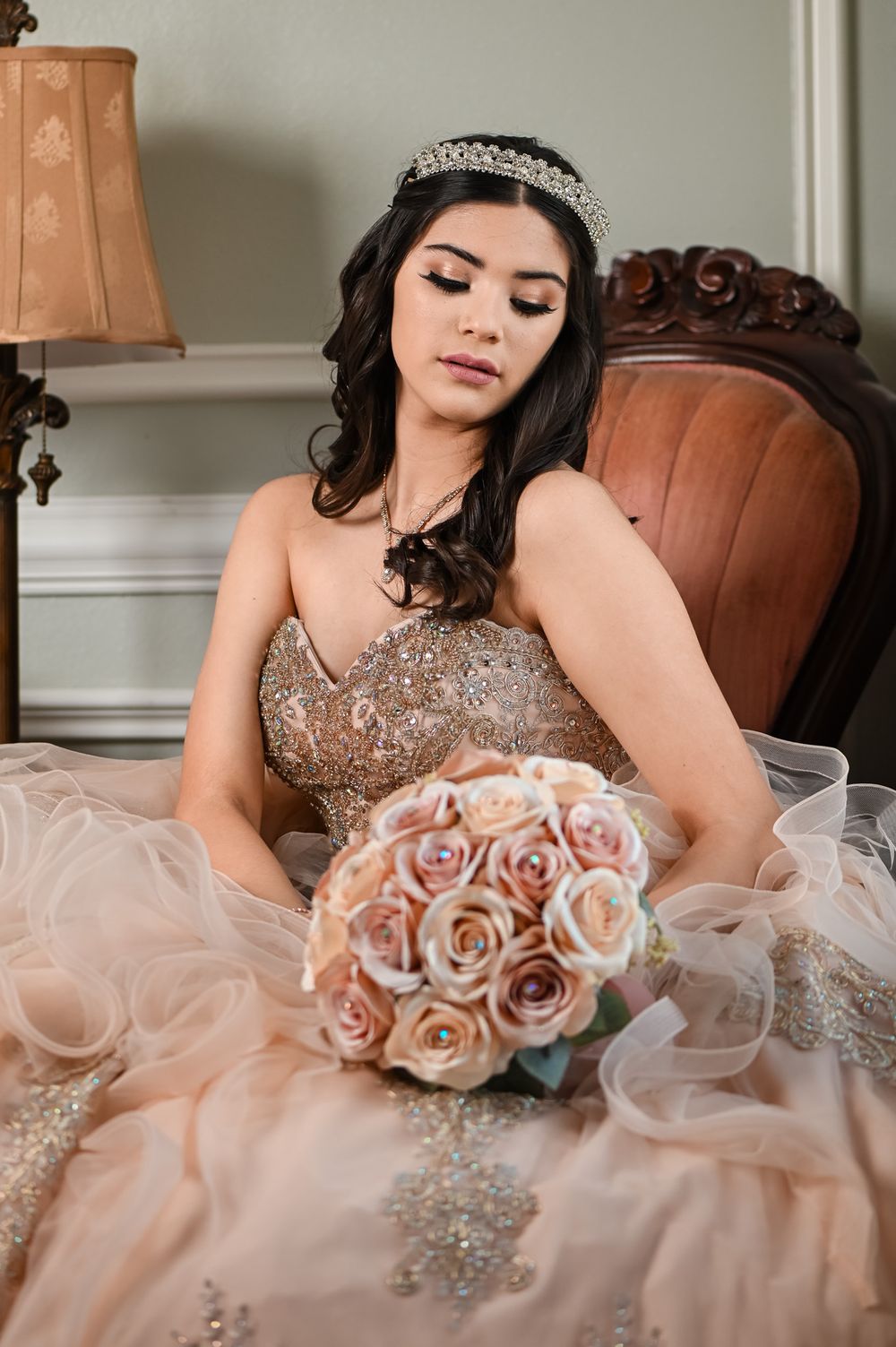 An intimate portrait featuring a crystal tiara and beaded blush gown with a rose bouquet.