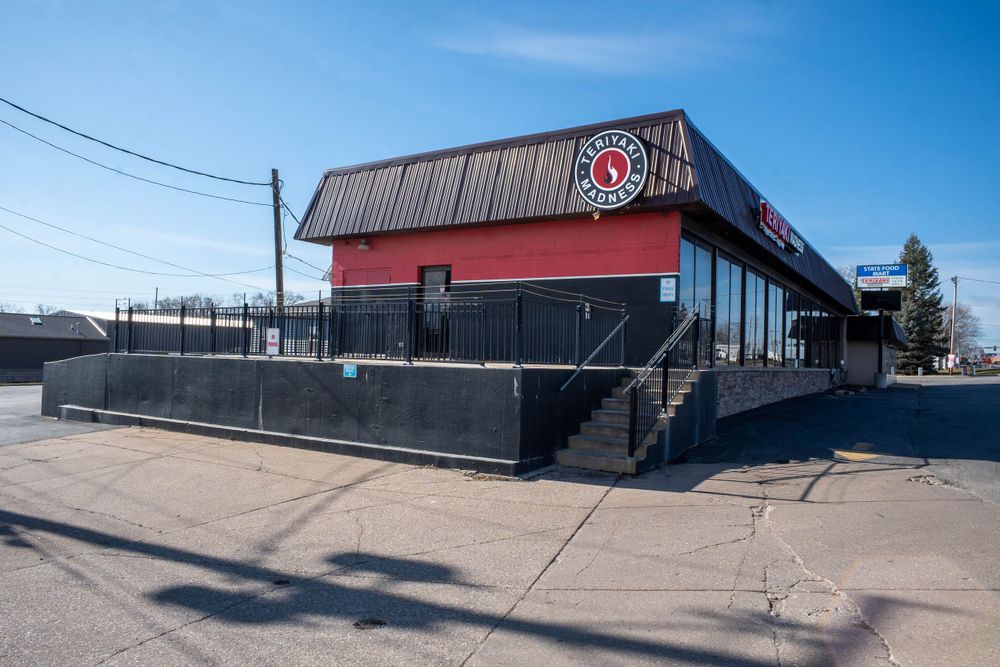 Modern black and red commercial building exterior with metal siding and concrete base. Quad Cities Real Estate Photography
