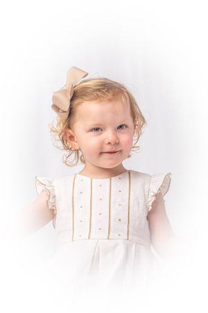 Memphis Heirloom photographic studio portrait of a blonde haired girl with a bow and white dress.