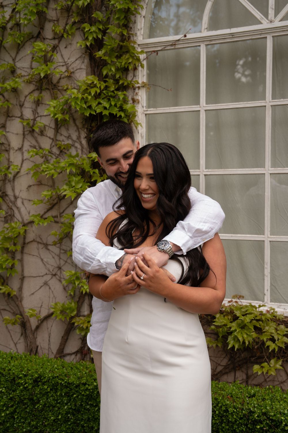 engaged couple hugging and laughing.