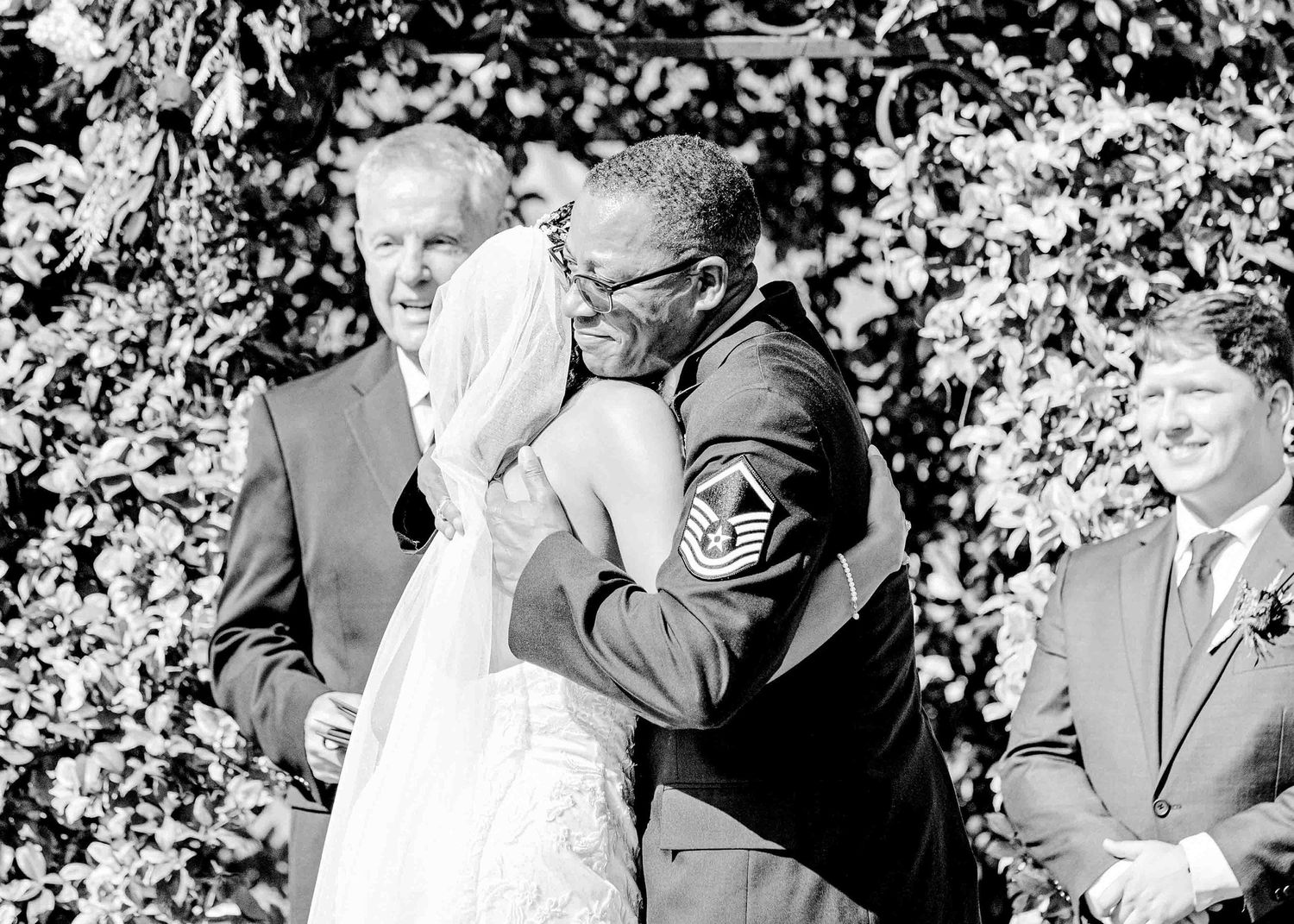 A black and white photograph of an emotional moment during a wedding ceremony.