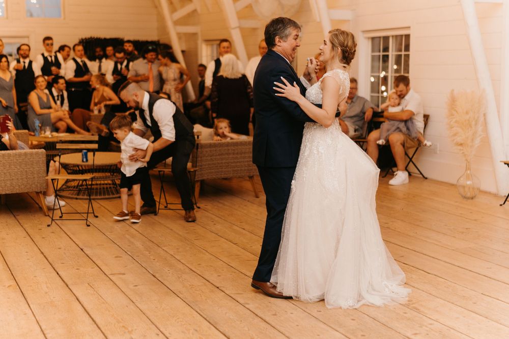 Bride and her father share an emotional dance together at a beautiful rustic barn wedding reception.