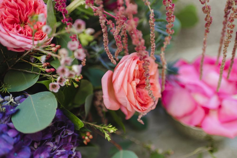 Vibrant floral arrangement featuring pink roses and purple blooms.