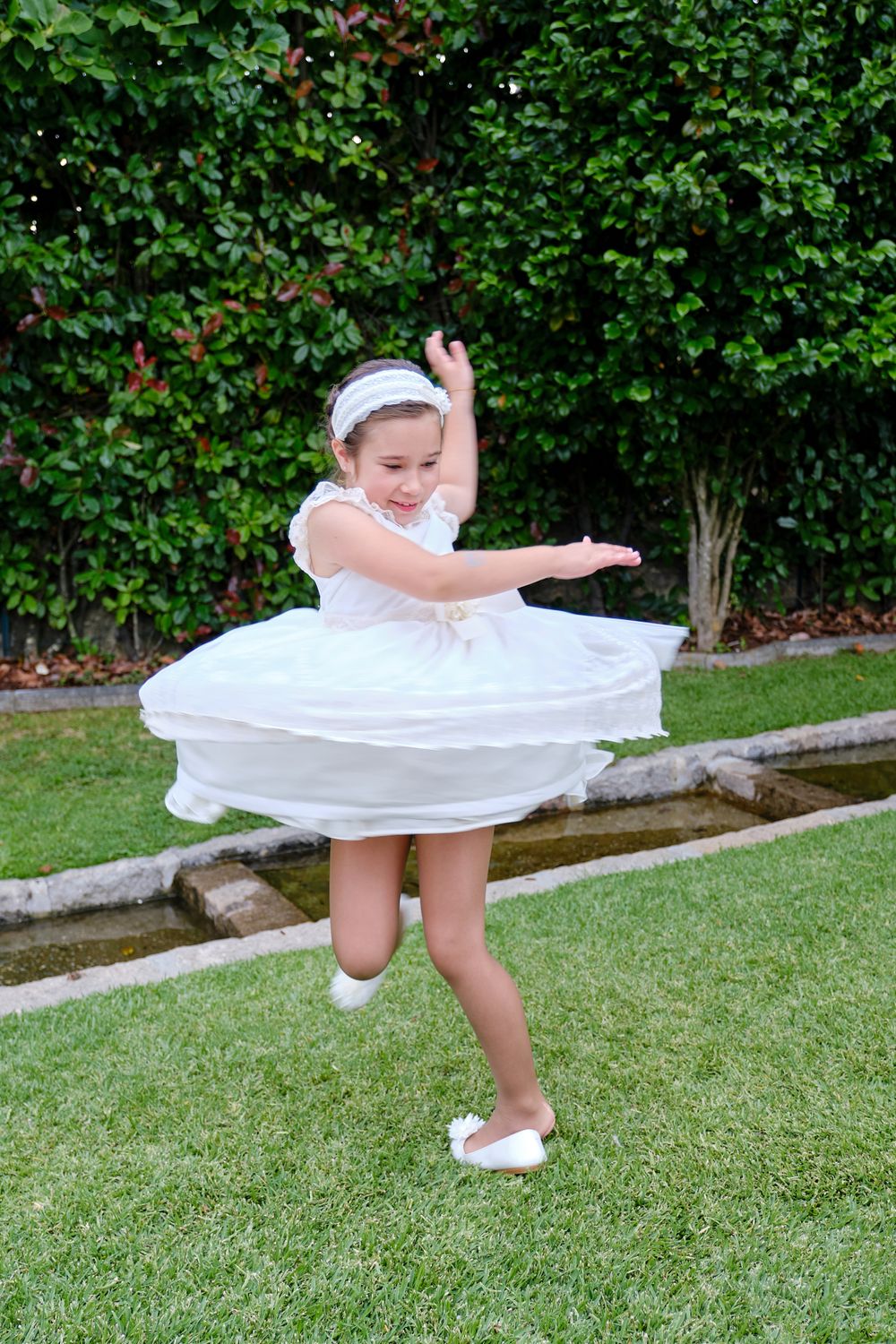 menina de comunhão a mostrar o vestido