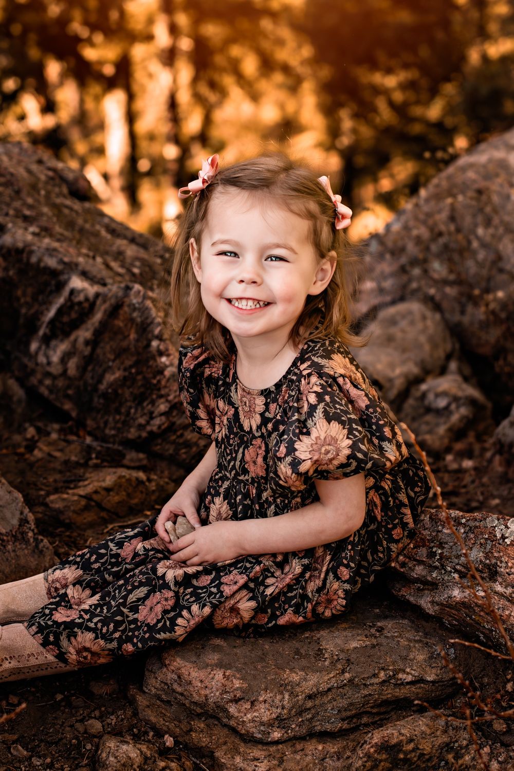 Young girl smiling with sunlight behind her on the Mount Falcon rocks