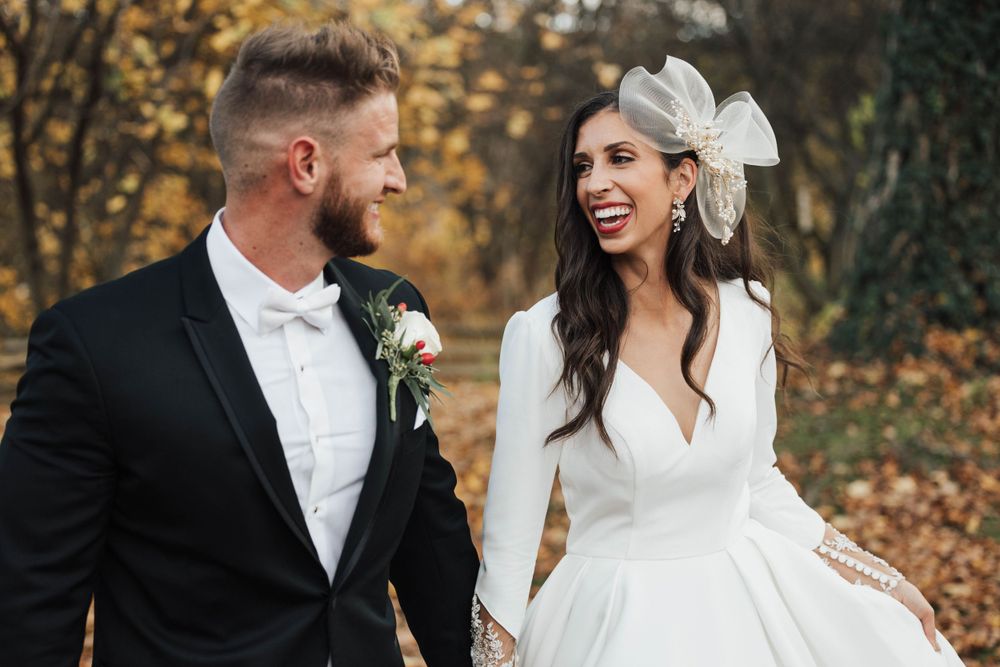 Bride and groom with bridal headpiece in fall foliage