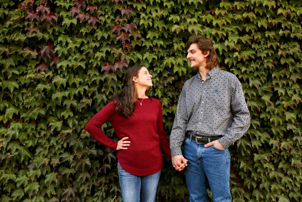 Couple standing in front of a lush Iowa hedge, celebrating a special moment