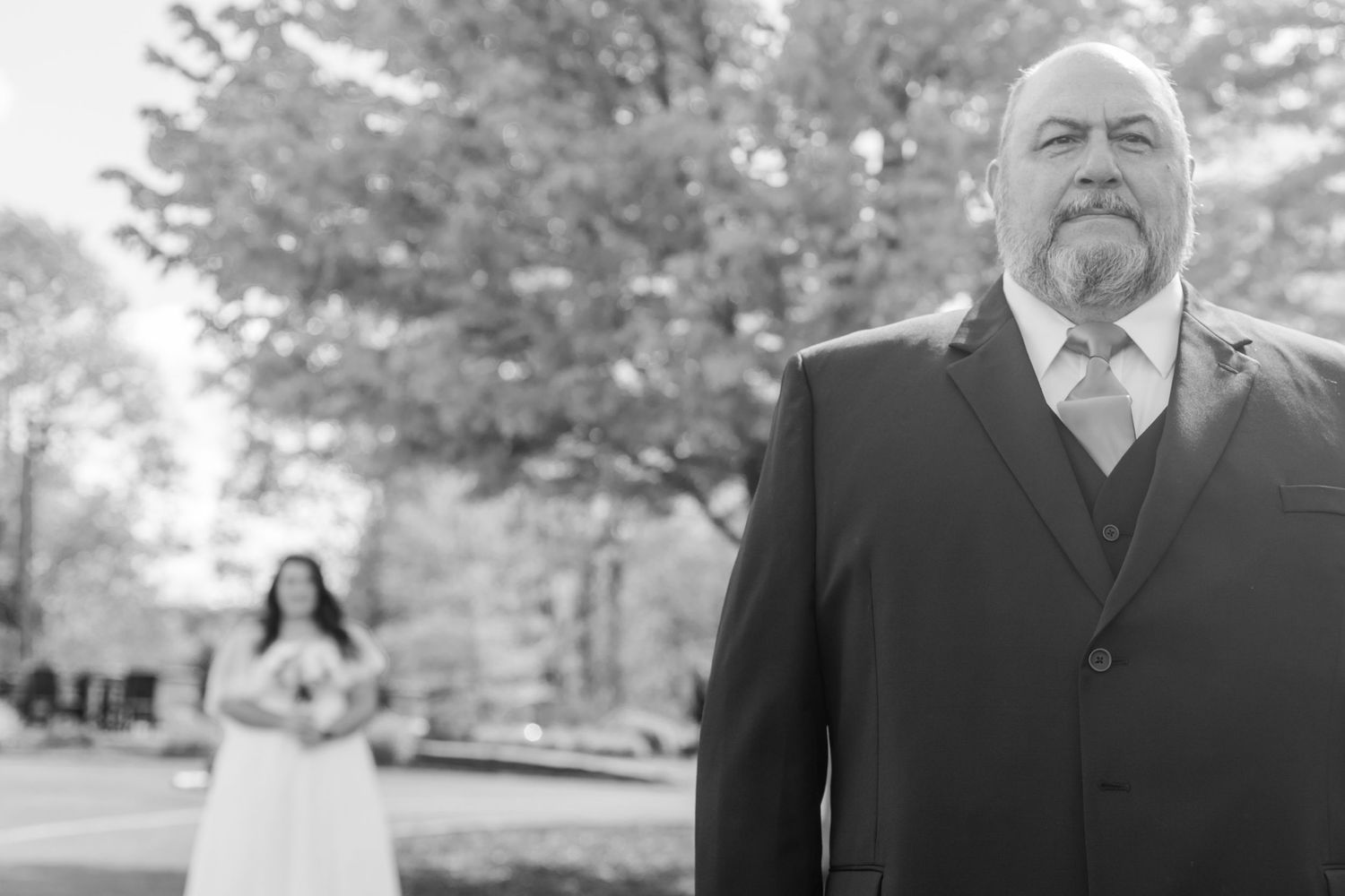Black and white outdoor wedding photography in a natural park setting.