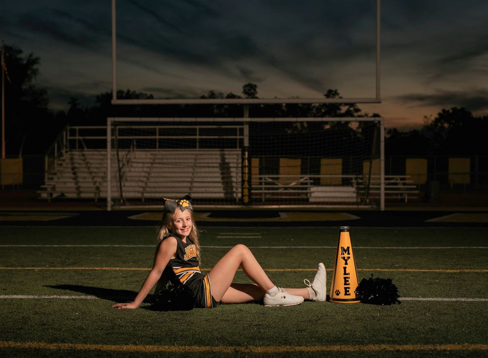 Dramatic sunset photo on football field with sports equipment.