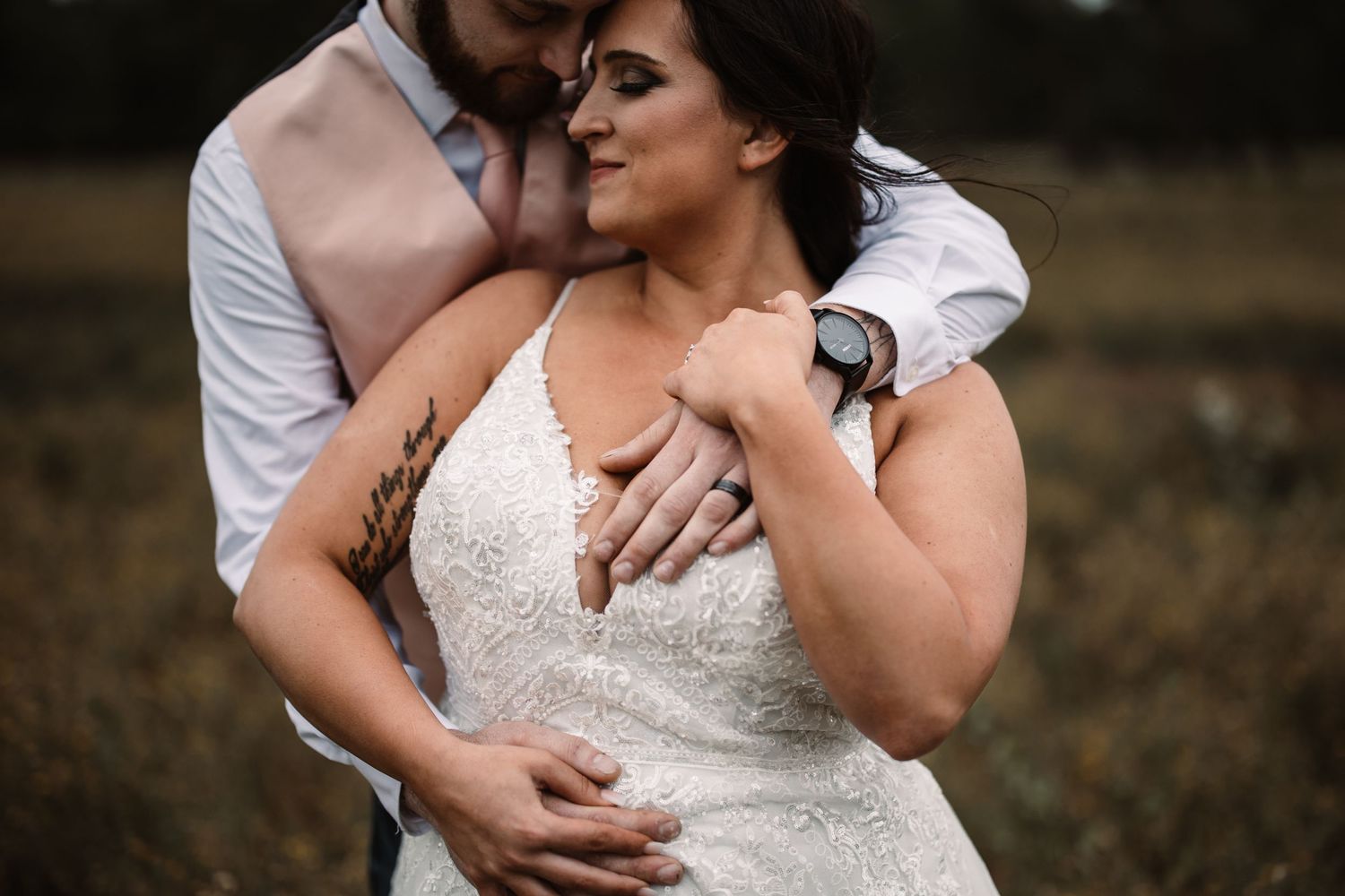 Intimate romantic moment captured against a moody rustic outdoor setting.