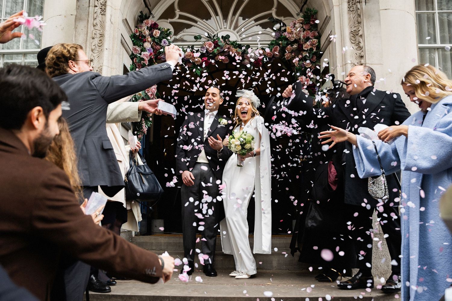 Emotive and fun confetti exit photography of the newlyweds at the Chelsea Old Town Hall