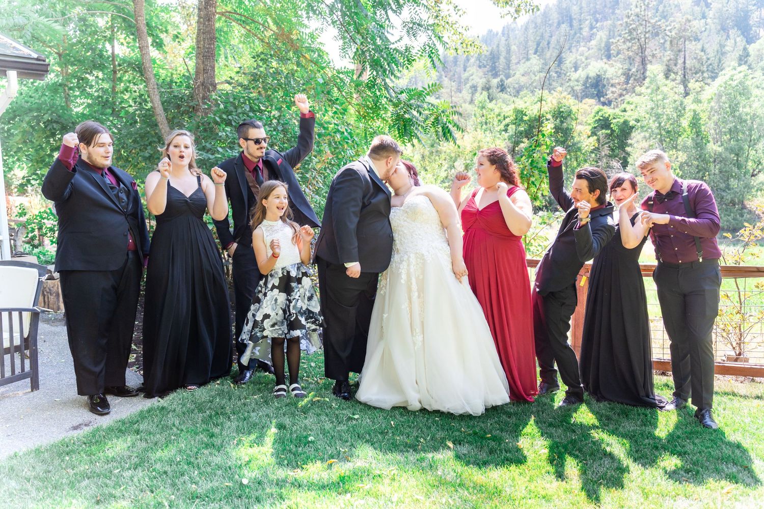 bridal party cheers while bride and groom kiss
