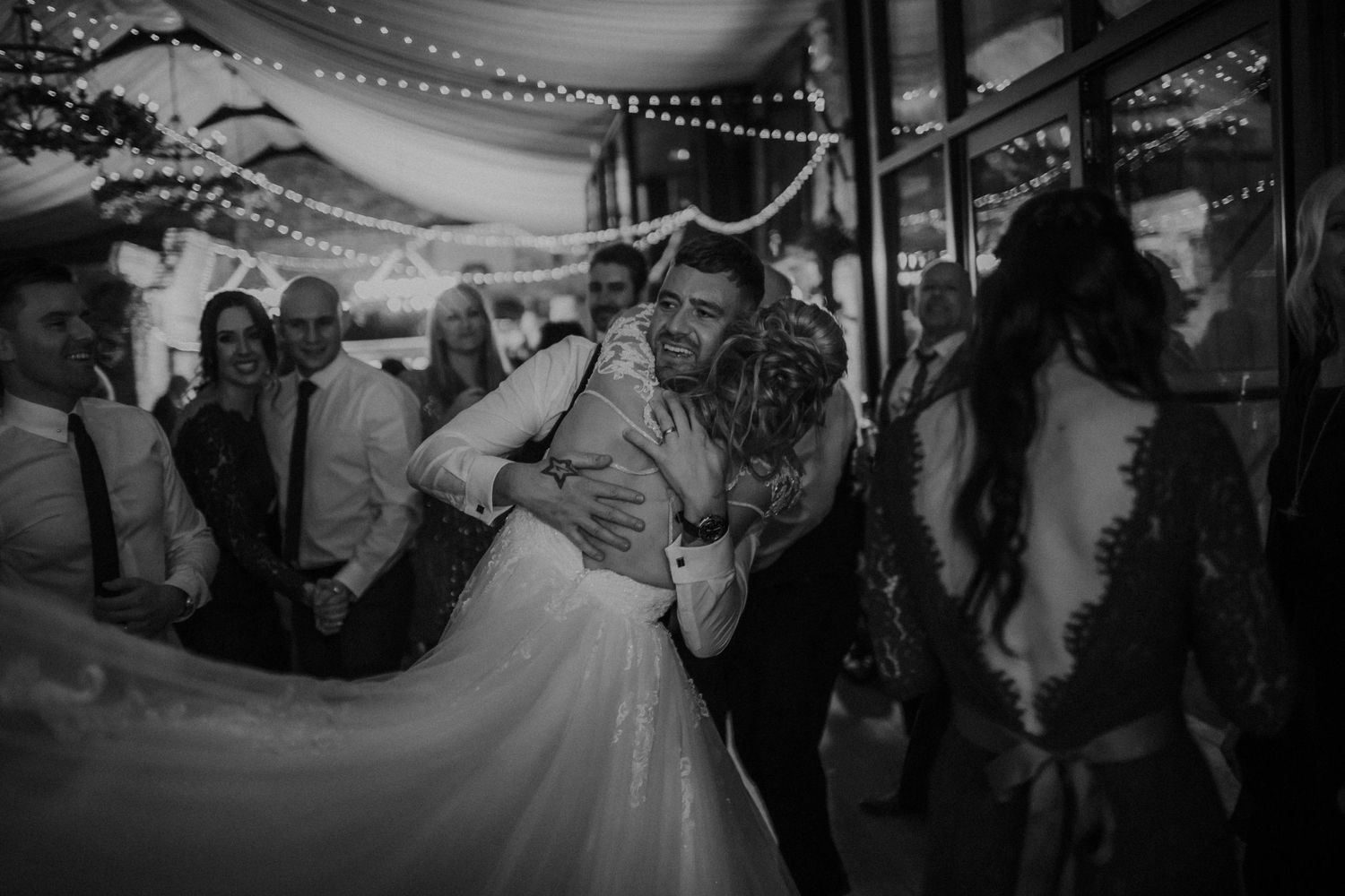 A couple dances together on their wedding day in a black and white photo showing romantic movement.