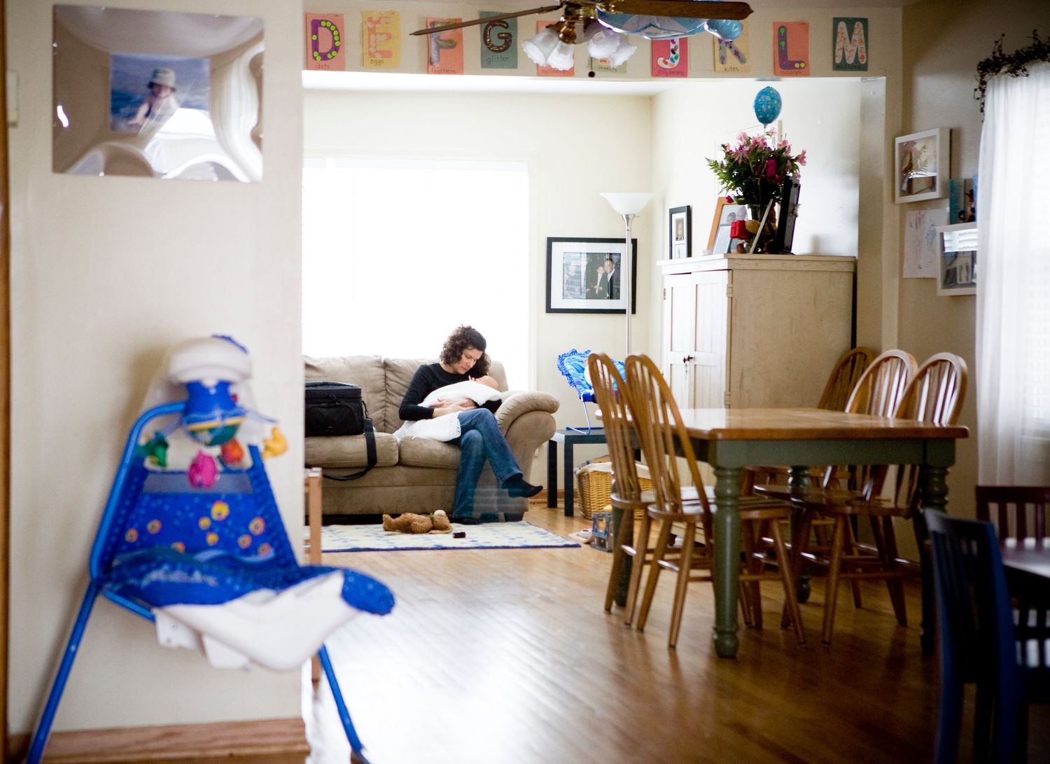 A cozy living room with wooden furniture, toys, and decorative banners hanging from the ceiling.