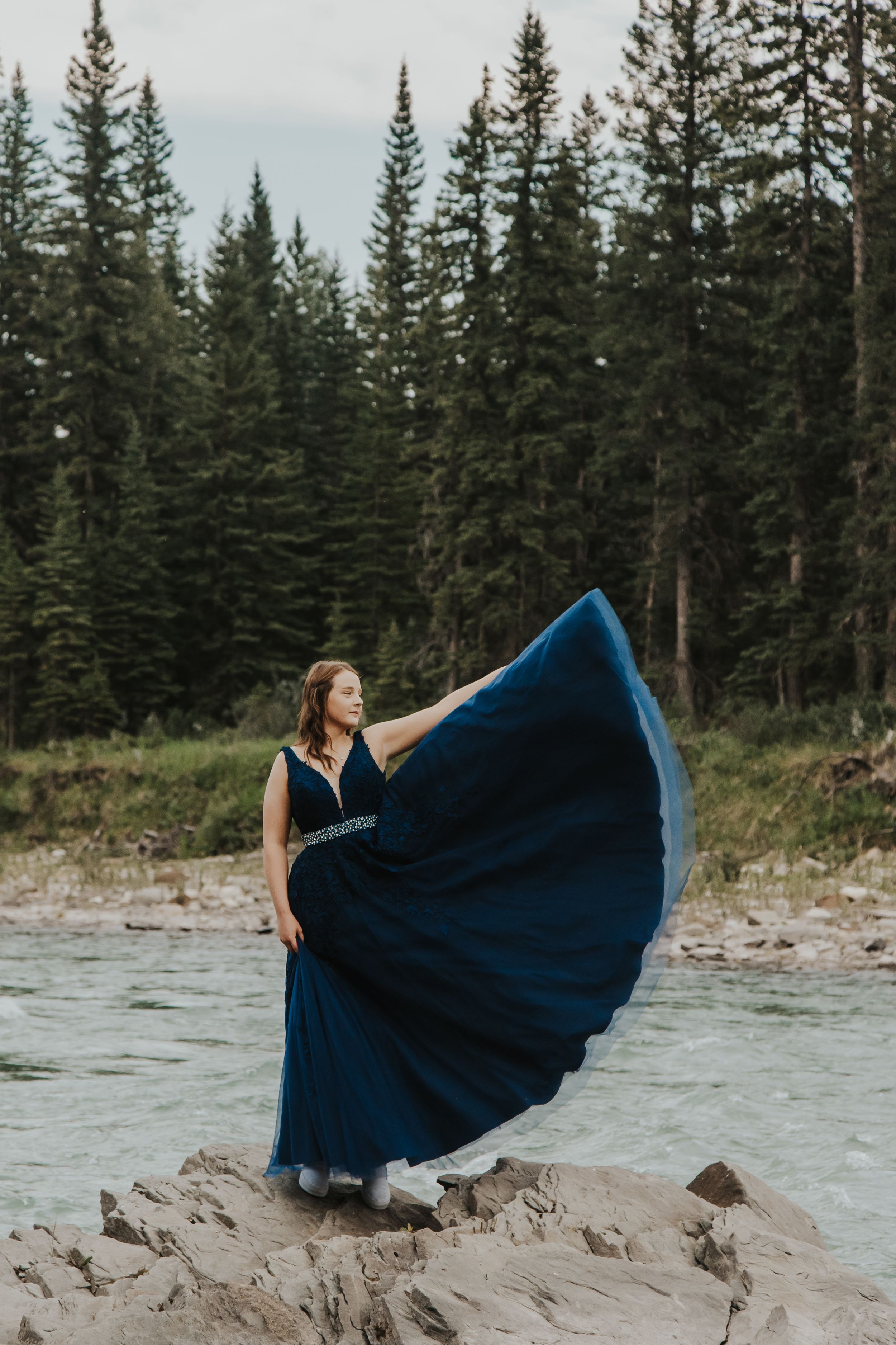 Girl in blue dress tosses dress into the air