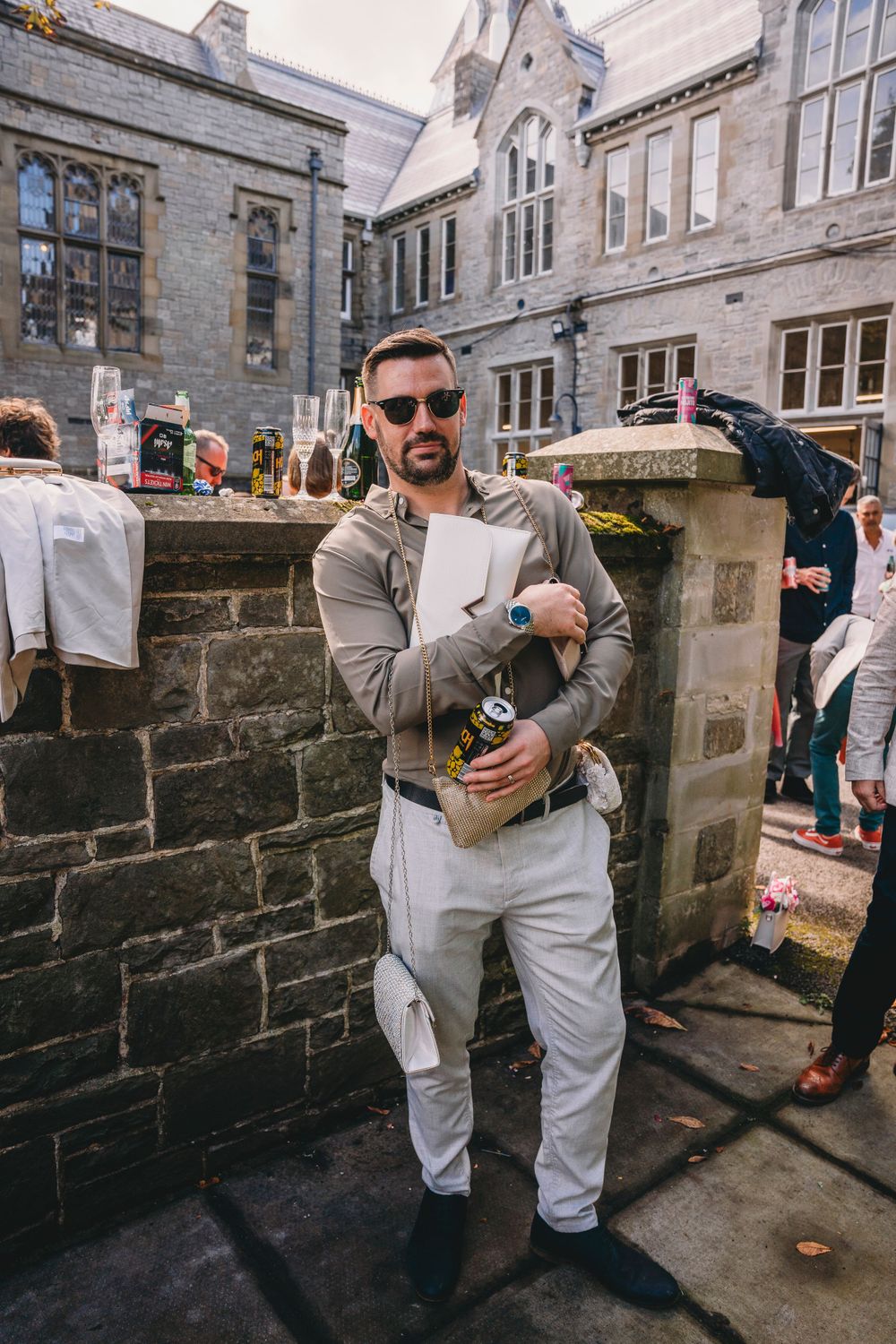 Wedding guest dancing and celebrating outside stone building venue.
