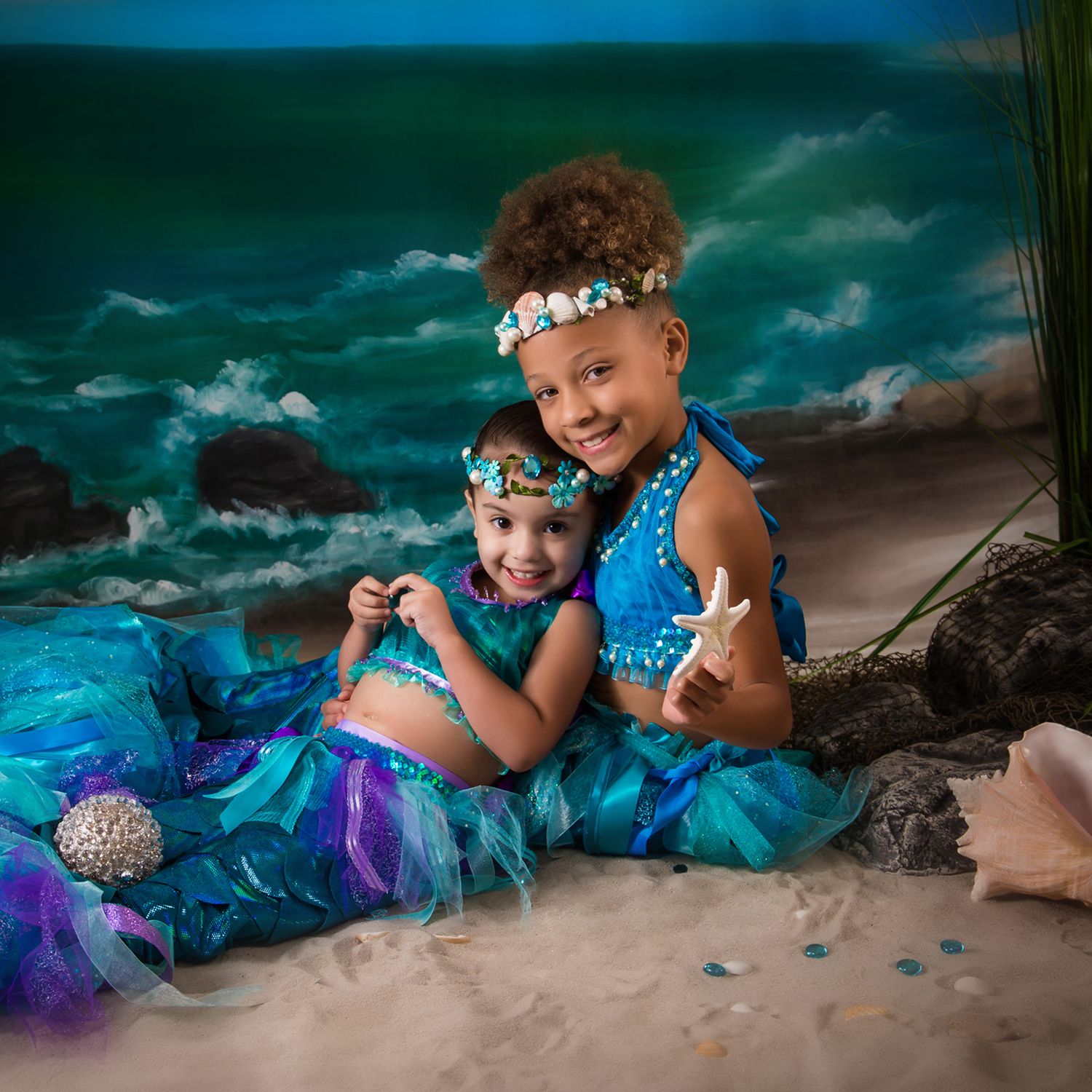 Whimsical beach photoshoot featuring matching turquoise and purple mermaid-inspired costumes.