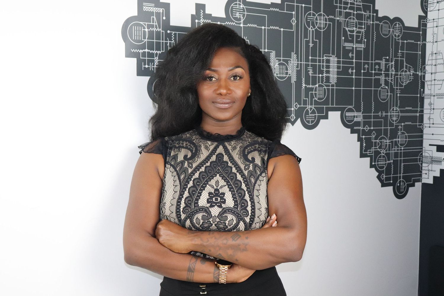 Studio fashion portrait against abstract cityscape wall wearing patterned sleeveless top.