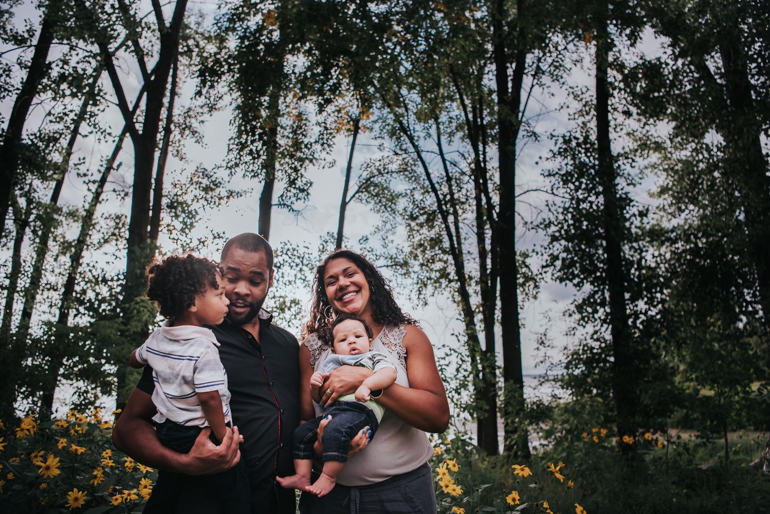 Colour image of black family standing in front of trees starting to change to Fall colours.