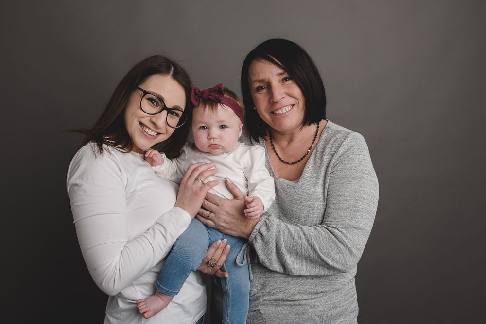 Studio portrait against grey backdrop capturing intimate family moments together.