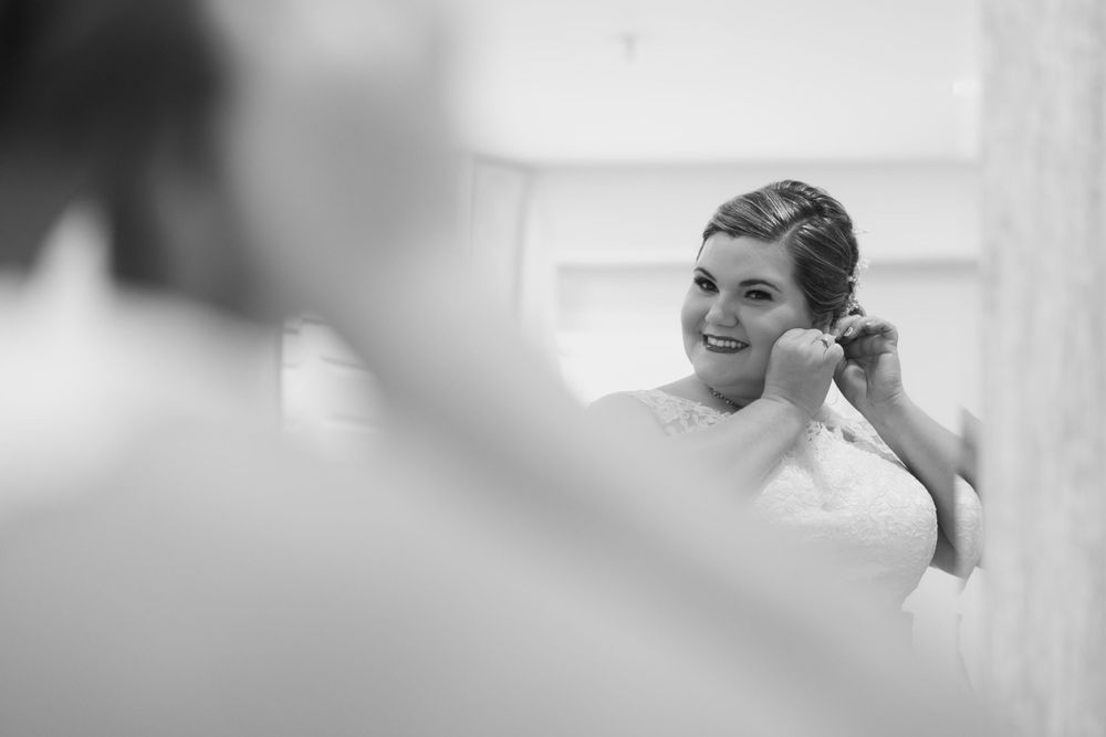 Black and white photo capturing a candid wedding preparation moment.