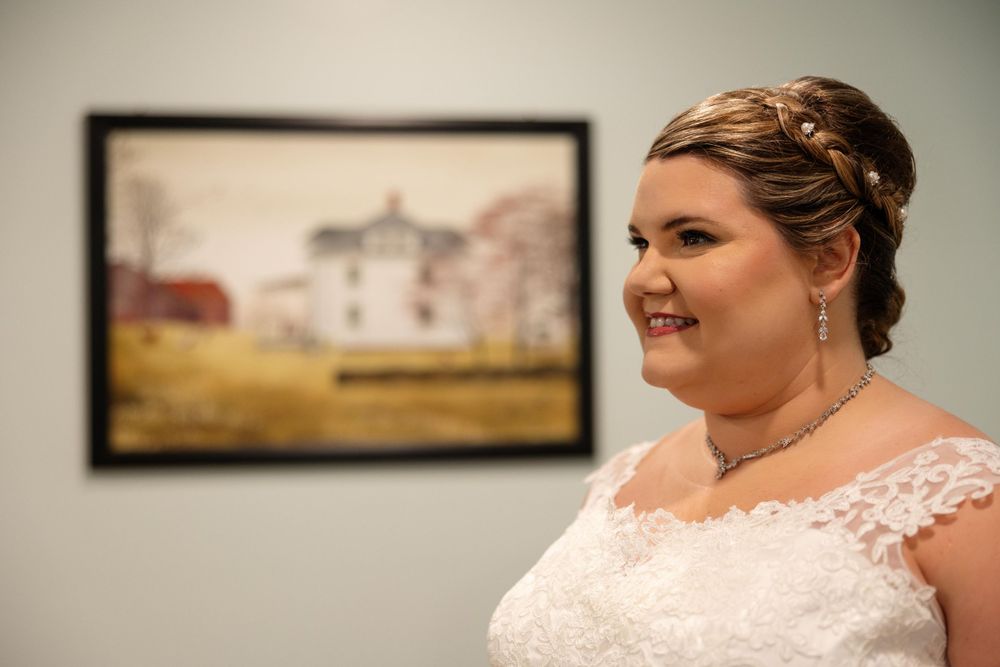 Beautiful portrait with rustic farmhouse painting in background.