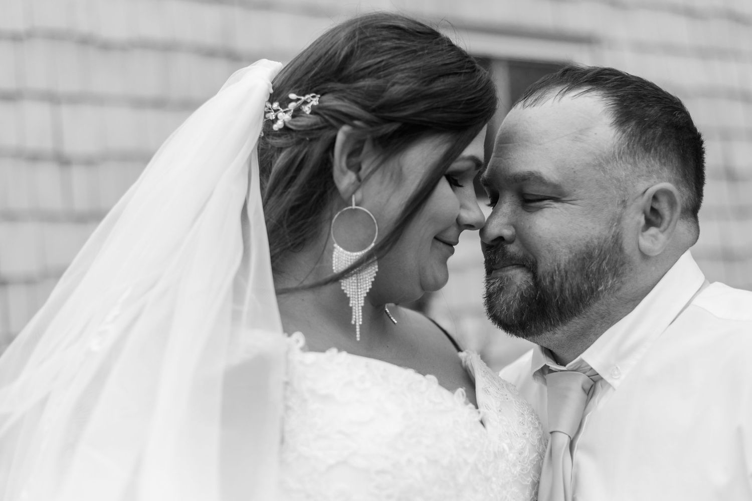Black and white wedding photos showing intimate moments between a couple in their wedding attire.