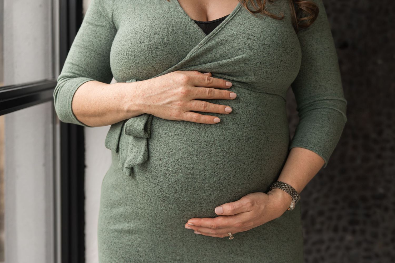 Pregnant women holding her stomach with two hands