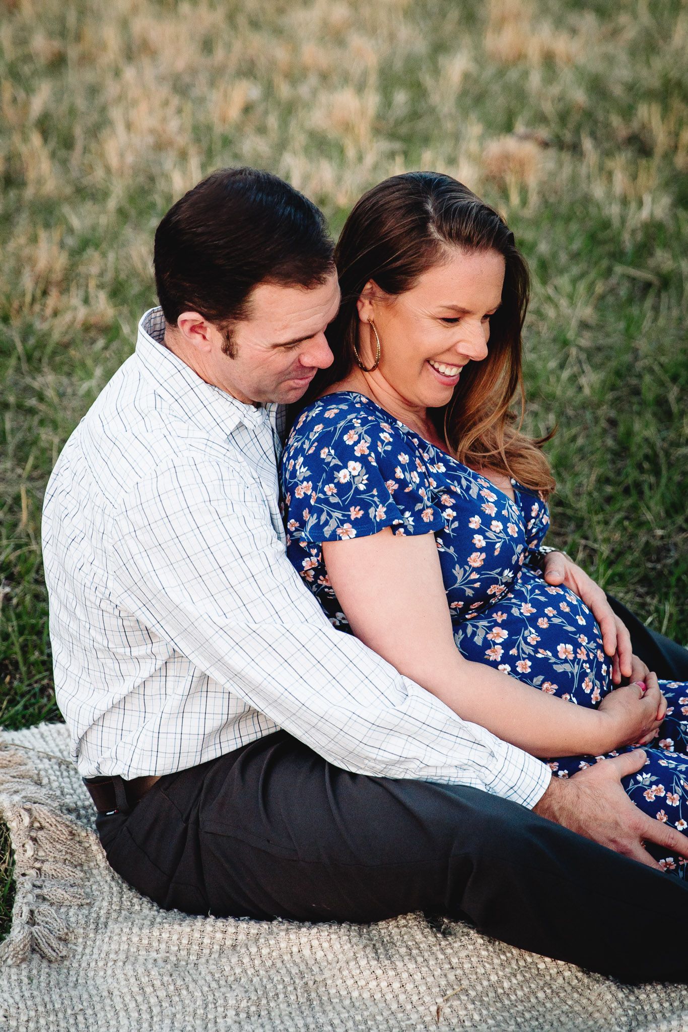 couple sitting on blanket laughing