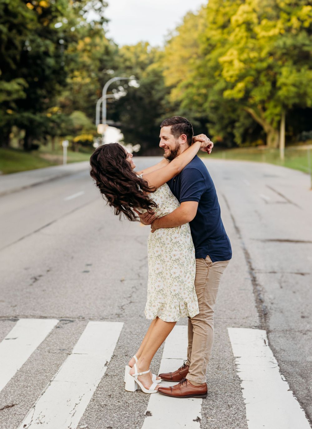 Couple sharing a romantic moment while dancing on a crosswalk.