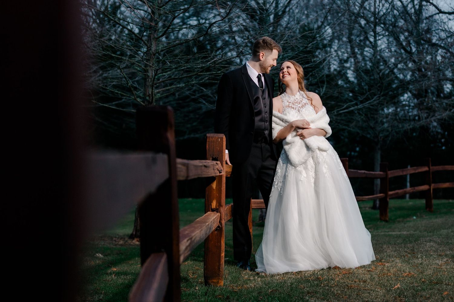 bride and groom posing agains a rail for a wedding photography