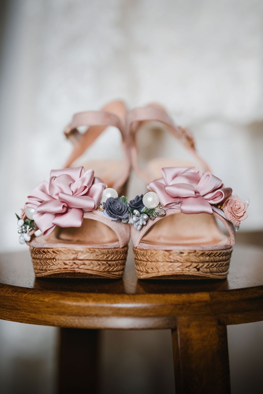 Elegant pink floral decorated wedding sandals with platform heels displayed on a wooden table.
Preston, Lancashire wedding photographer.