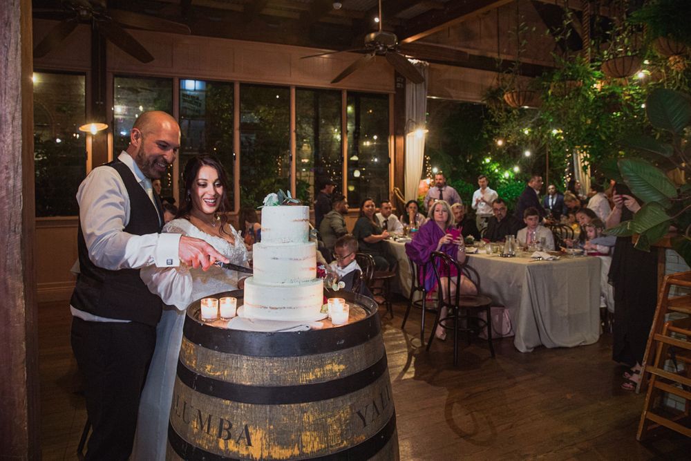 Wedding reception venue decorated with rustic wine barrels and elegant floral arrangements.