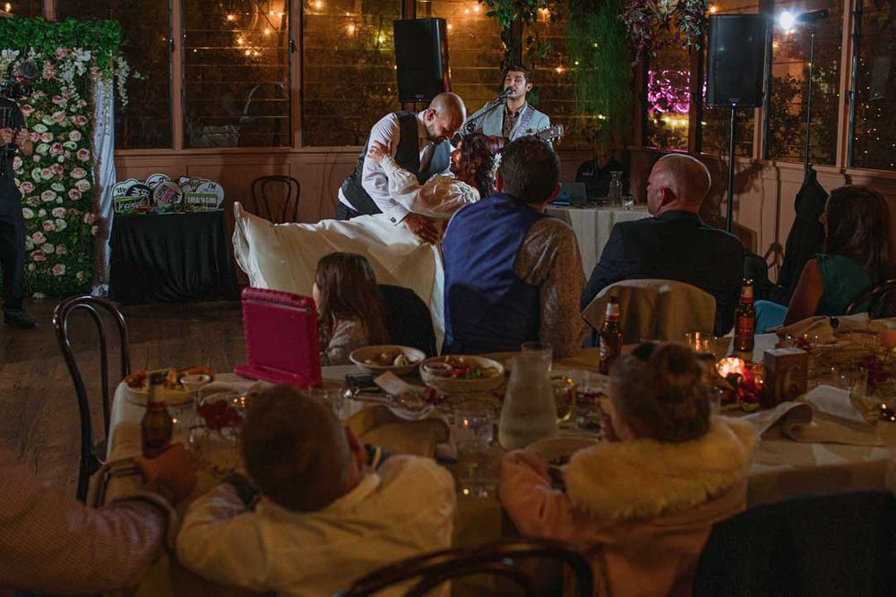 Wedding guests watching entertainment from their seats in a romantically lit reception venue.