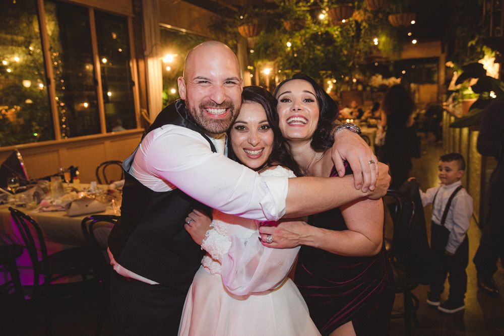 Wedding party guests dancing and celebrating joyfully at a lively reception.