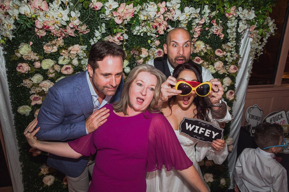 Guests dancing and having fun at a wedding reception with floral decorations.