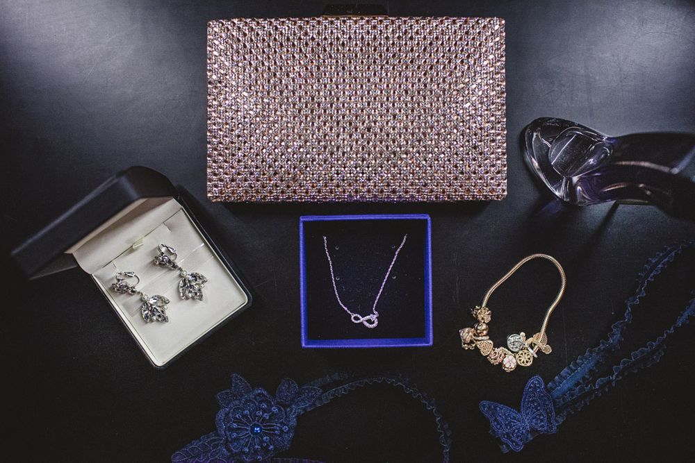 Elegant jewelry and accessories displayed on dark background with blue lighting accents.