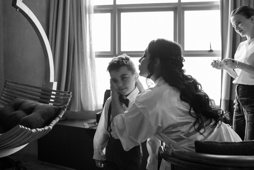 Black and white panoramic series of wedding preparation moments near windows.